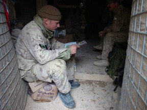 A soldier from A-Company 2 PPCLI catches up on some reading on Christmas morning at Forward Operating Base Mas'um Ghar west of Kandahar City,  Afghanistan.