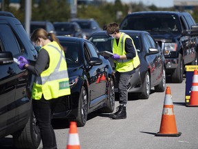 Paramedics register patients at a drive through, pop-up COVID-19 test centre outside the Canadian Tire Centre in Ottawa, Sunday, Sept. 20, 2020.