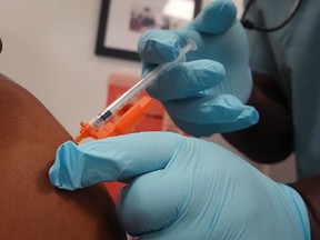 A worker at Roseland Community Hospital receives the COVID-19 vaccine in Chicago, on Dec. 18, 2020.