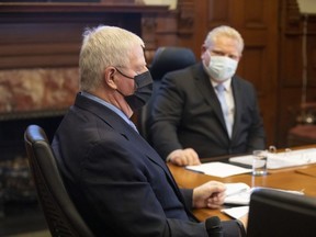Ontario Premier Doug Ford, right, speaks with retired chief of national defence staff Gen. Rick Hillier, chair of the COVID-19 Vaccine Distribution Task Force, during a meeting at the Queen's Park in Toronto on Friday December 4, 2020.