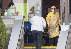 Arrivals are greeted by workers in full personal protective equipment at Sunnycrest Nursing Home in Whitby Wednesday, Dec. 9, 2020.