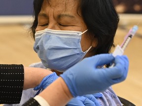 The first Pfizer-BioNTech COVID-19 vaccine in Ontario is administered to personal support worker Anita Quidangen at a hospital in Toronto on Monday, Dec. 14, 2020.