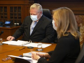 Ontario Premier Doug Ford sits alongside Health Minister Christine Elliott during a Vaccine Distribution Task Force meeting at the Queen's Park in Toronto on December 4, 2020.
