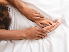 A man and woman enjoy sexual foreplay in bed.