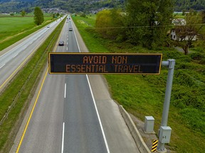 An electronic message board over the Trans-Canada Highway advising people to avoid non-essential travel.