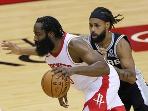 James Harden of the Houston Rockets drives past Patty Mills of the San Antonio Spurs at the Toyota Center on December 17, 2020 in Houston.