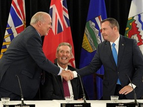 Alberta Premier Jason Kenney (right) shakes hands with British Columbia Premier John Horgan (left) as Manitoba Premier Brian Pallister (middle) looks on after the meeting of the Premiers from the provinces of Alberta, British Columbia, Manitoba, Saskatchewan and the three Territories concluded June 27, 2019.