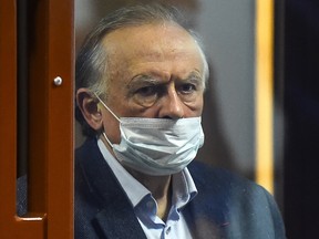 Russian historian Oleg Sokolov, accused of murdering and dismembering his former student lover, stands inside a defendants' cage during his verdict hearing in Saint Petersburg on December 25, 2020.