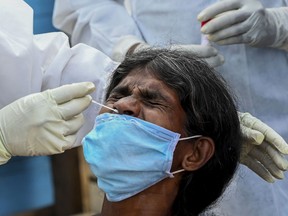 A medical worker collects a swab sample from a resident to test for COVID19 in Colombo, Sri Lanka.
