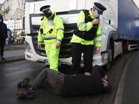 Police officers attend to a man at the Port of Dover on December 23, 2020 in Dover, United Kingdom.