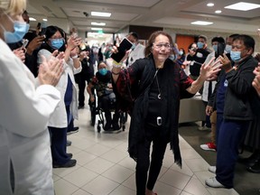 Intensive Care Unit Nurse Merlin Pambuan, 66, is cheered by hospital staff as she walks out of the hospital where she spent 8 months with the coronavirus disease at Dignity Health – St. Mary Medical Center, in Long Beach, California December 21, 2020.