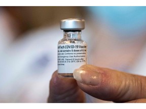 A healthcare worker holds a Pfizer-BioNtech Covid-19 vaccine at Memorial Healthcare System, in Miramar, Florida on December 14, 2020. - The United States kicked off a mass vaccination drive Monday hoping to turn the tide on the world's biggest coronavirus outbreak, as the country's death toll neared a staggering 300,000. (Photo by CHANDAN KHANNA / AFP)