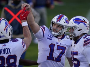 Bills quarterback Josh Allen (centre) celebrates with tight end Dawson Knox (left) after a touchdown during Saturday’s game against the Broncos in Denver. Buffalo captured its first AFC East crown with a victory in the Mile High City.