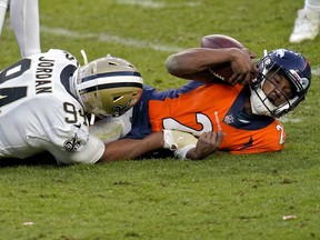 Saints defensive end Cameron Jordan (lef) sacks Broncos quarterback Kendall Hinton this past Sunday in Denver. Hinton, a wide receiver, was thrust into duty after all four of the Broncos’ QBs were placed in COVID quarantine.