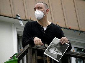 Aaron Ashley Karapinka holds a photograph of his father while reflecting on his death at his home in Edmonton, Dec. 11, 2020. His father Merv Karapinka died in hospital on Dec. 7 from COVID-19.