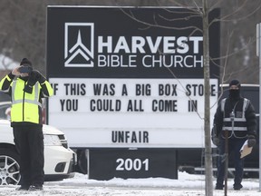 Church followers stand by a sign at Harvest Bible Church in Windsor on the morning of Dec. 27, 2020.
