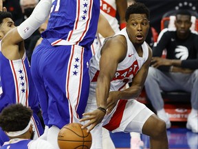 Raptors’ Kyle Lowry dishes the ball under the net during the first quarter of Tuesday night’s game against the 76ers at Wells Fargo Center in Philadelphia.