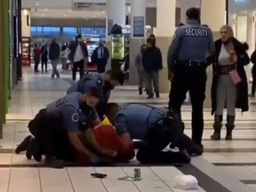 Josh Walker is restrained by security guards at Upper Canada Mall in Newmarket on Dec. 11, 2020.