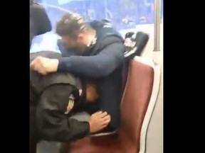 In a screengrab from video posted to Twitter, TTC fare collectors struggle with a 501 streetcar passenger on Feb. 7, 2020.