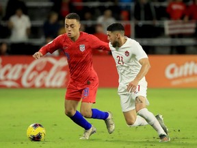 Sergino Dest (No. 18) of the United States dribbles against Jonathan Osorio (No. 21) of Canada during the CONCACAF Nations League match at Exploria Stadium on November 15, 2019 in Orlando, Florida.