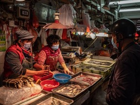 Residents wearing face masks purchase seafood at a wet market on January 28, 2020 in Macau, China.