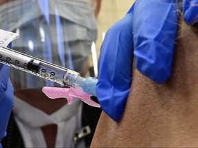 A Pfizer-BioNTech COVID-19 vaccine is administered at a University Health Network hospital in Toronto on Monday, Dec. 14, 2020.