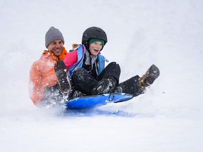 Matt Tymchuk and his daughter Joelle, 10, spend the Christmas afternoon tobogganing down the hill in Confederation Park on Friday, December 25, 2020. v