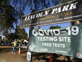 People wait in line at a  a coronavirus testing and vaccination site at Lincoln Park on Dec. 30, 2020 in Los Angeles, Calif.