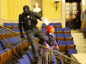 Protesters -- one holding zip ties -- enter the Senate Chamber on January 6, 2021 in Washington, D.C.