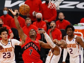 Kyle Lowry of the Toronto Raptors looses the ball as he attempts a shot over Jevon Carter of the Phoenix Suns during the first half of the NBA game at Phoenix Suns Arena on January 06, 2021 in Phoenix, Arizona.
