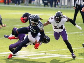 Running back Derrick Henry #22 of the Tennessee Titans attempts to break a tackle from linebacker L.J. Fort #58 of the Baltimore Ravens during the fourth quarter of their AFC Wild Card Playoff game at Nissan Stadium on January 10, 2021 in Nashville, Tennessee.