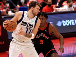 Mavericks’ Luka Doncic (right) was held in check by Stanley Johnson in the Raptors win on Monday night.