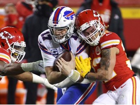 Josh Allen of the Buffalo Bills is tackled by Tyrann Mathieu  and Alex Okafor of the Kansas City Chiefs in the second half during the AFC Championship game at Arrowhead Stadium on January 24, 2021 in Kansas City, Missouri.