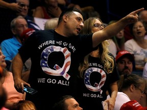 Supporters wearing shirts with the QAnon logo, chat before U.S. President Donald Trump takes the stage during his Make America Great Again rally in Wilkes-Barre, Pa., Aug. 2, 2018.