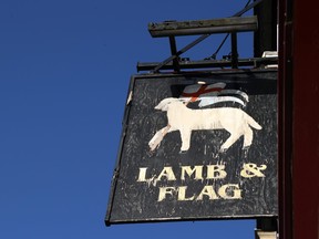 A sign for The Lamb and Flag is seen as the Grade-II listed pub is forced to close, after more than 400 years of business in central Oxford, Britain, Jan. 25, 2021.