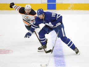 Maple Leafs Jason Spezza skates the puck past Edmonton Oilers forward Kailer Yamamoto at Scotiabank Arena.