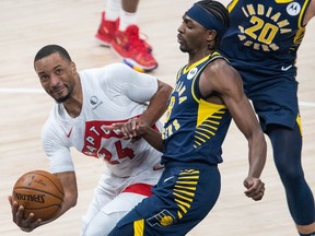 Raptors guard Norman Powell (24) drives to the basket while Indiana Pacers guard Justin Holiday (8) defends in the third quarter at Bankers Life Fieldhouse on Monday night.