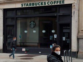 A man wearing a mask walks in front of a shuttered Starbucks as the spread of the COVID-19 outbreak continues in Manhattan in April.