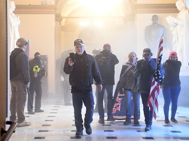 Supporters of US President Donald Trump enter the US Capitol as tear gas fills the corridor on January 6, 2021, in Washington, DC.  (Photo by SAUL LOEB/AFP via Getty Images)