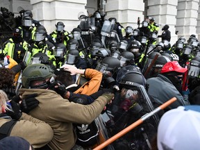Riot police push back a crowd of supporters of U.S. President Donald Trump after they stormed the Capitol building on January 6, 2021 in Washington, DC.