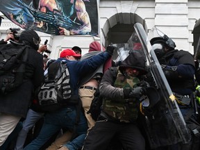 Riot police push back a crowd of supporters of US President Donald Trump after they stormed the Capitol building in Washington, DC Jan. 6, 2021.