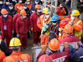 One (C-blue helmet) of 22 Chinese miners is saved from hundreds of metres underground where they had been trapped for two weeks after a gold mine explosion in Qixia, in eastern China's Shandong province on Jan. 24, 2021.