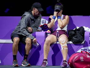 Bianca Andreescu speaks to her coach, Sylvain Bruneau, after sustaining an injury during the 2019 Shiseido WTA Finals at Shenzhen Bay Sports Center on October 30, 2019 in Shenzhen, China.