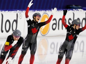 From left, Canadian team pursuit speedskaters Isabelle Weidemann, Valérie Maltais and Ivanie Blondin celebrate their track record and gold medal in Heerenveen, Netherlands on Friday.