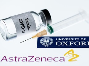 This file illustration taken in Paris on November 23, 2020 shows a syringe and a vial reading "COVID-19 Vaccine" next to AstraZeneca company and University of Oxford logos.