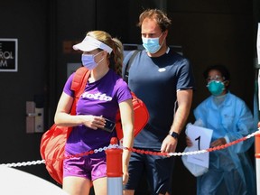 A tennis player and coach leave their hotel to train in Melbourne on Sunday, Jan 17, 2021, as players quarantine in hotels ahead of the Australian Open.