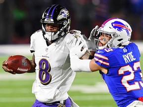 Baltimore Ravens quarterback Lamar Jackson (8) stiff arms Buffalo Bills strong safety Micah Hyde (23) during the AFC Divisional Round playoff game in Buffalo.