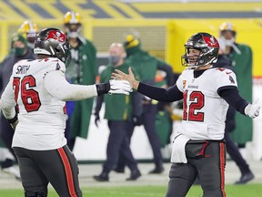 Tom Brady of the Tampa Bay Buccaneers celebrates with teammate Donovan Smith during the NFC Championship game at Lambeau Field on January 24, 2021 in Green Bay, Wisconsin.