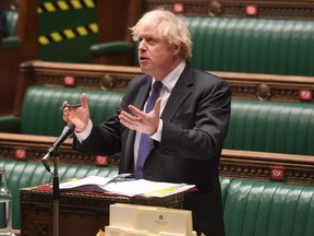 A handout photograph released by the U.K. Parliament shows Britain's Prime Minister Boris Johnson attending the weekly Prime Minister's Questions in the House of Commons in London, Wednesday, Jan. 20, 2021.