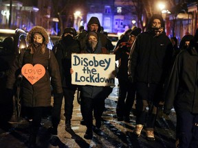 Protesters walk down streets as they ignore a night curfew imposed by the Quebec government to help slow the spread of the COVID-19 pandemic in Montreal, Jan. 9, 2021.